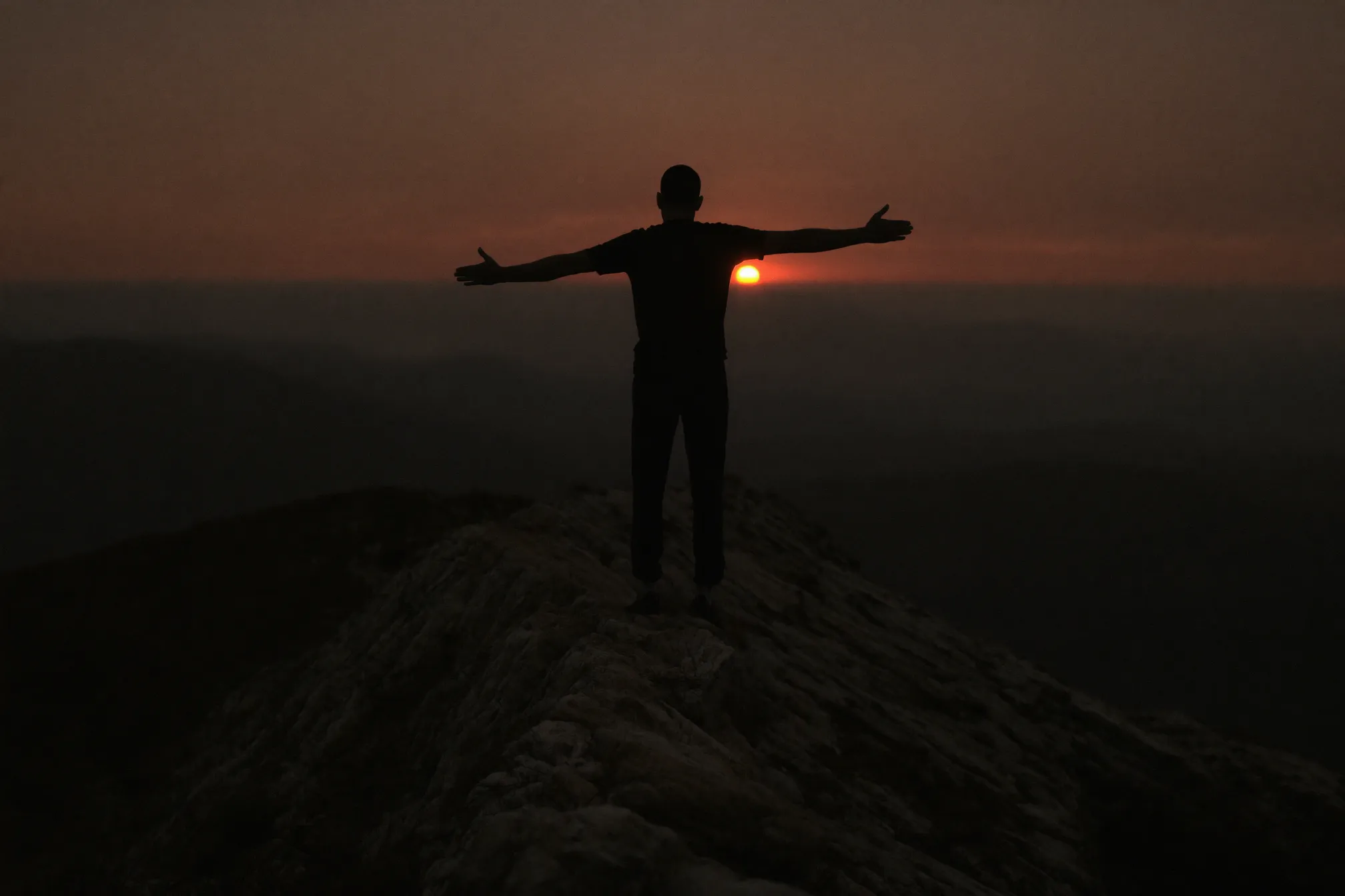 Man on a mountain ridge at dawn